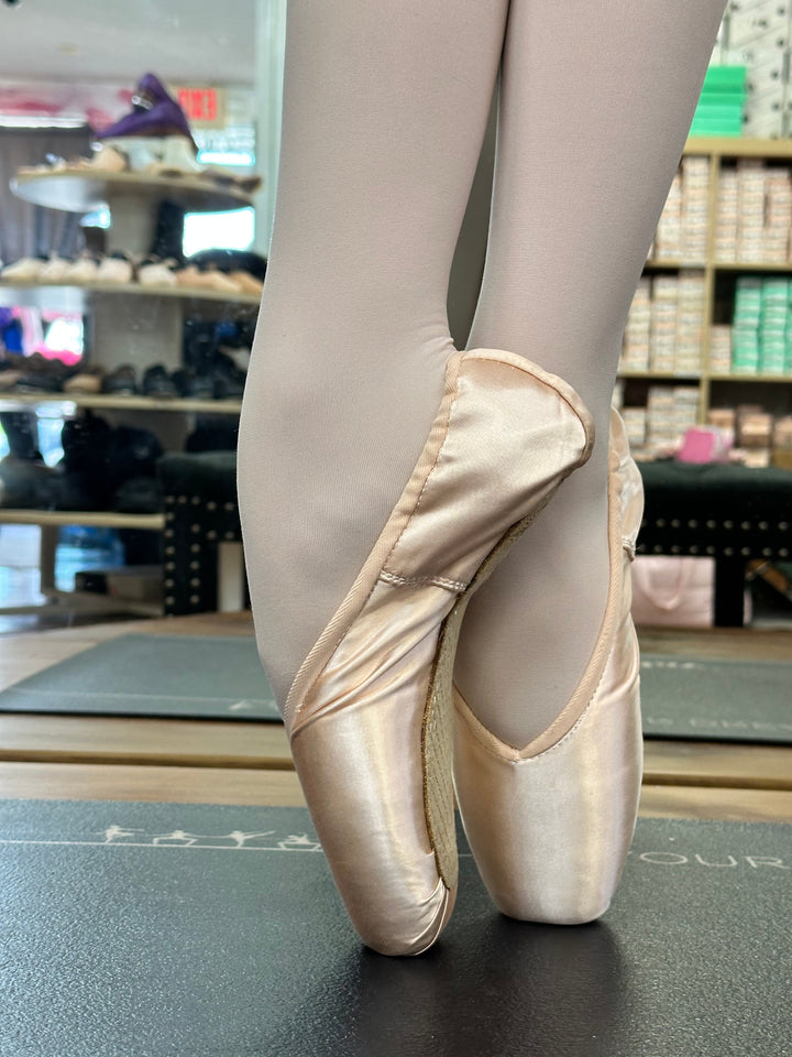 Ballet shoes with beige tights against a store background