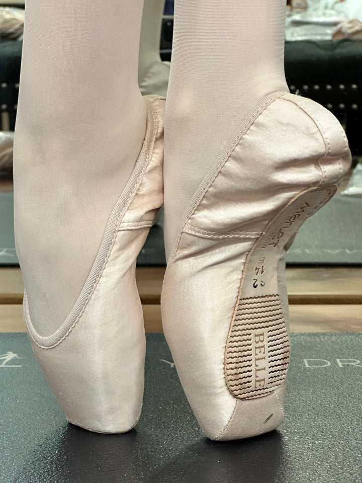 Close-up of beige ballet shoes with &